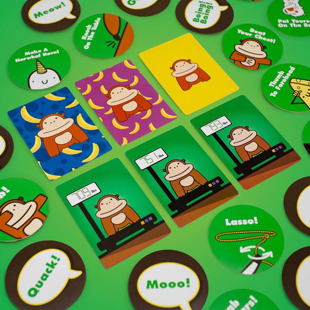 some of the game cards featuring gorillas with different backgrounds and gorillas on scales, also circular cards with actions on them