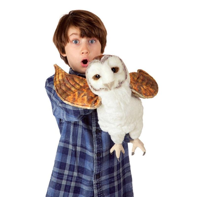 Young boy holding owl puppet making it "fly" toward the camera.