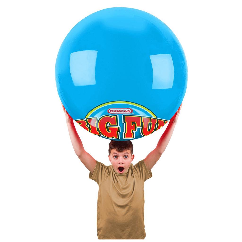 Boy with surprised face holds ball over his head.
