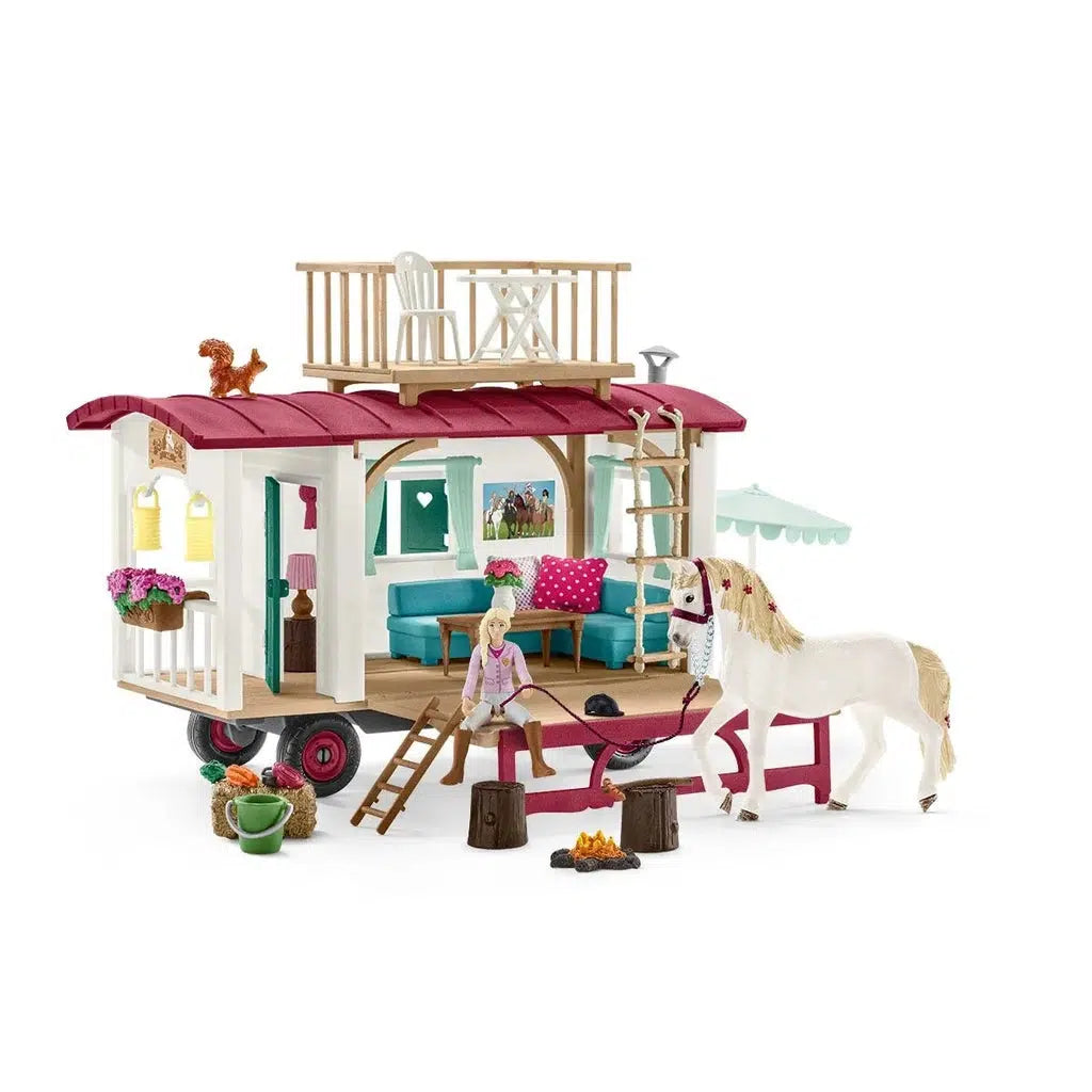 Image of the play set outside of the packaging. It comes with a white and pink caravan stocked with furniture and interior decorations. The set also comes with a girl rider and a horse.