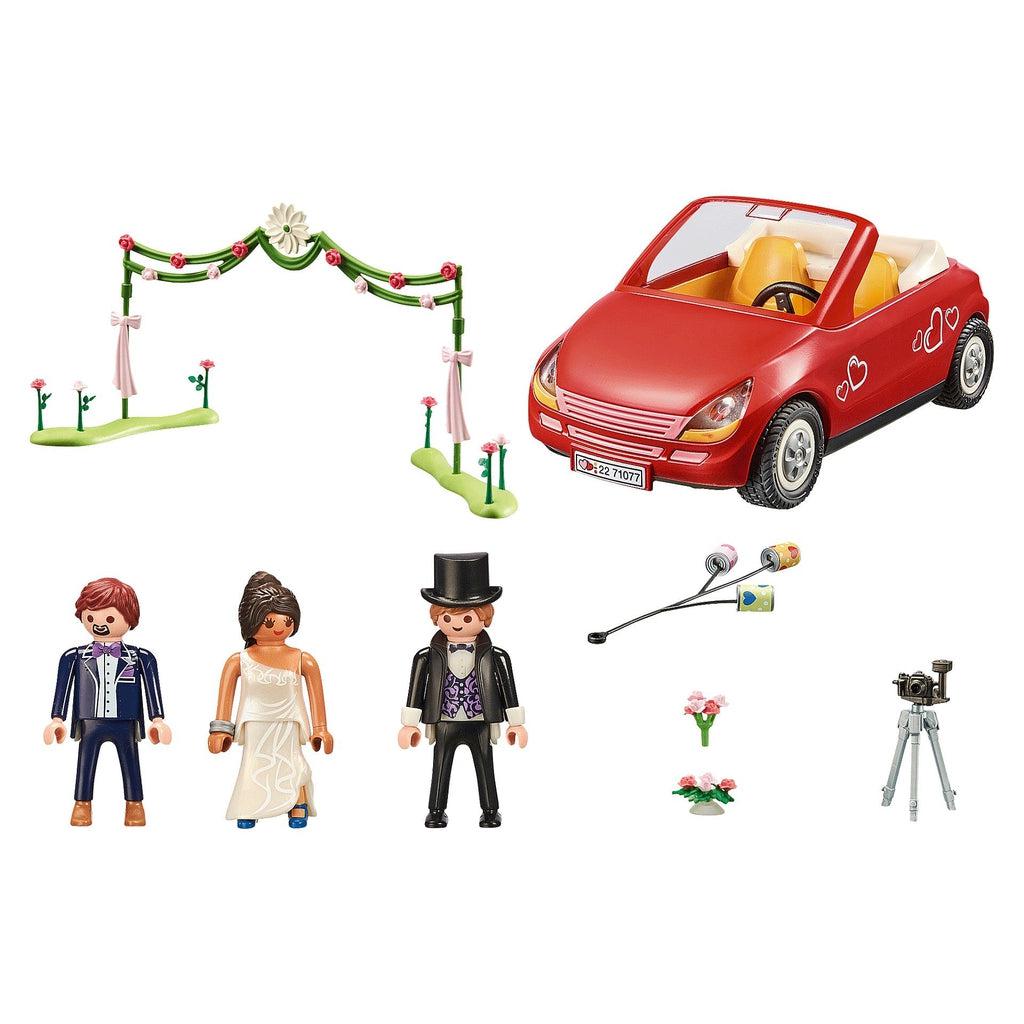 This image shows what comes in the pack, including the car, cans to tie to the fender, an arch made of wrreaths, flowers, bride, groom, photographer, and camera. 