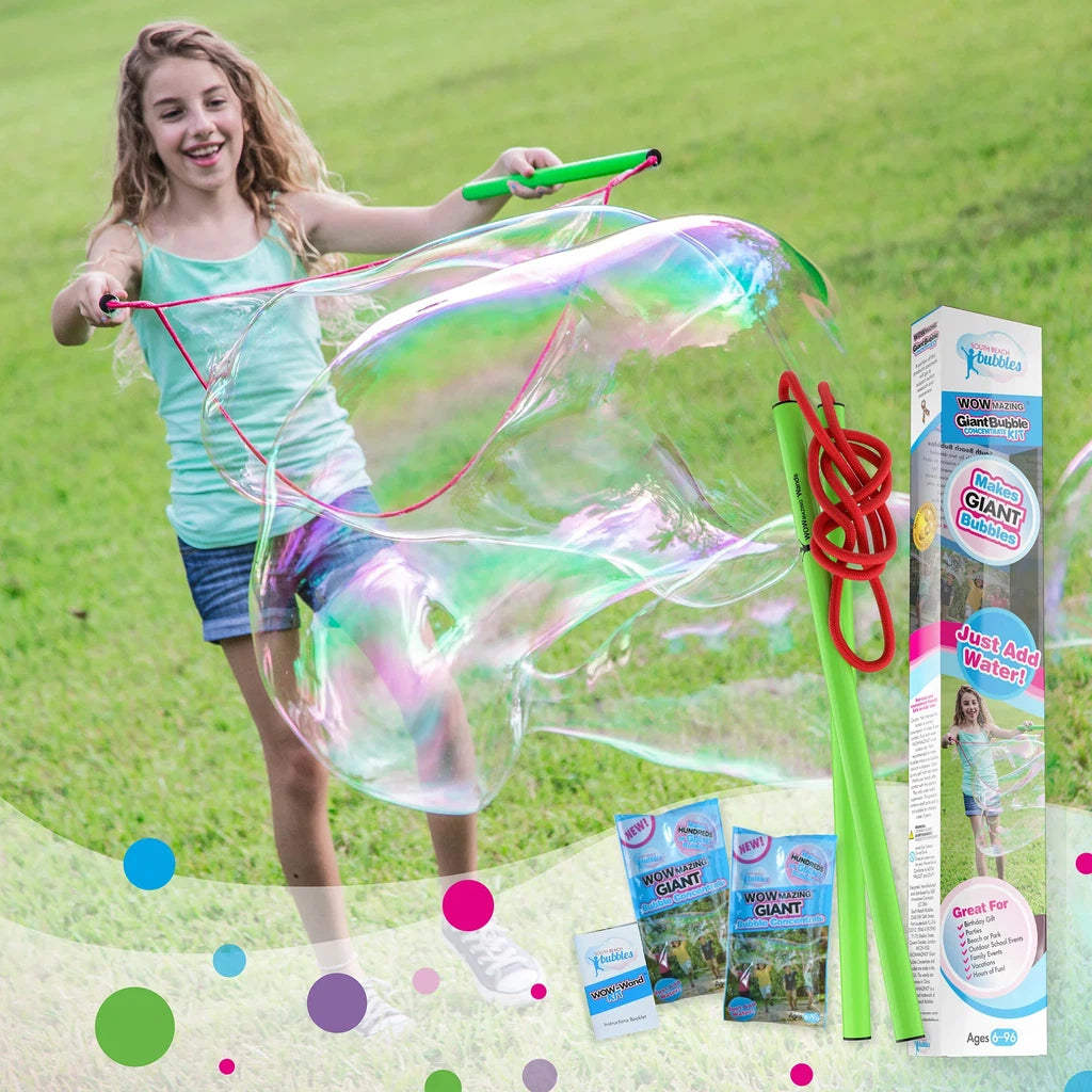 A girl is playing with high-flying bubbles in a grassy field.