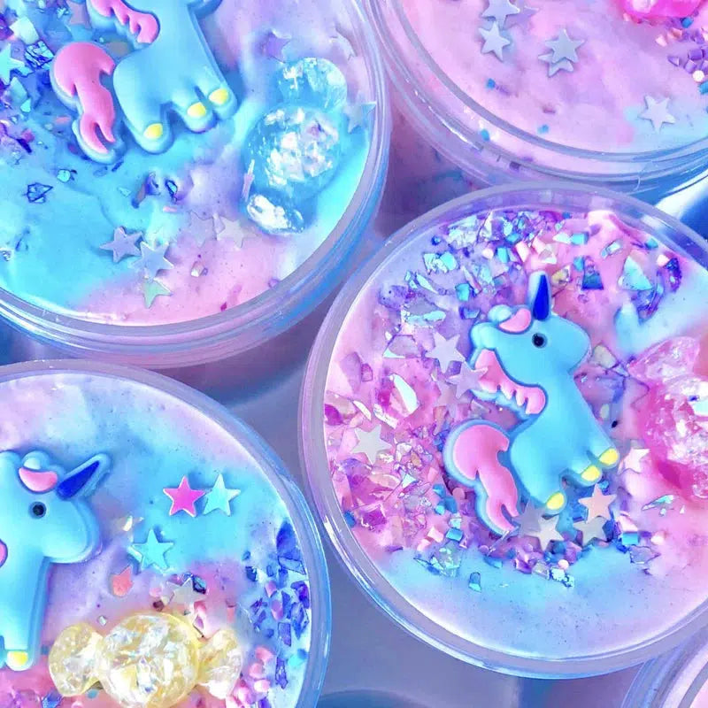 this image shows 4 tubs of slime with unicorns on top. 