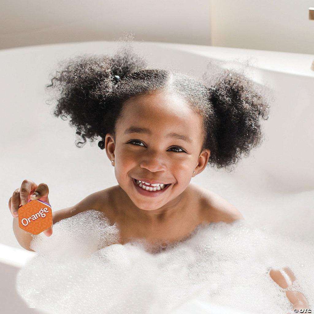 Scene of a little girl smiling while holding one of the puzzle pieces in the bath.