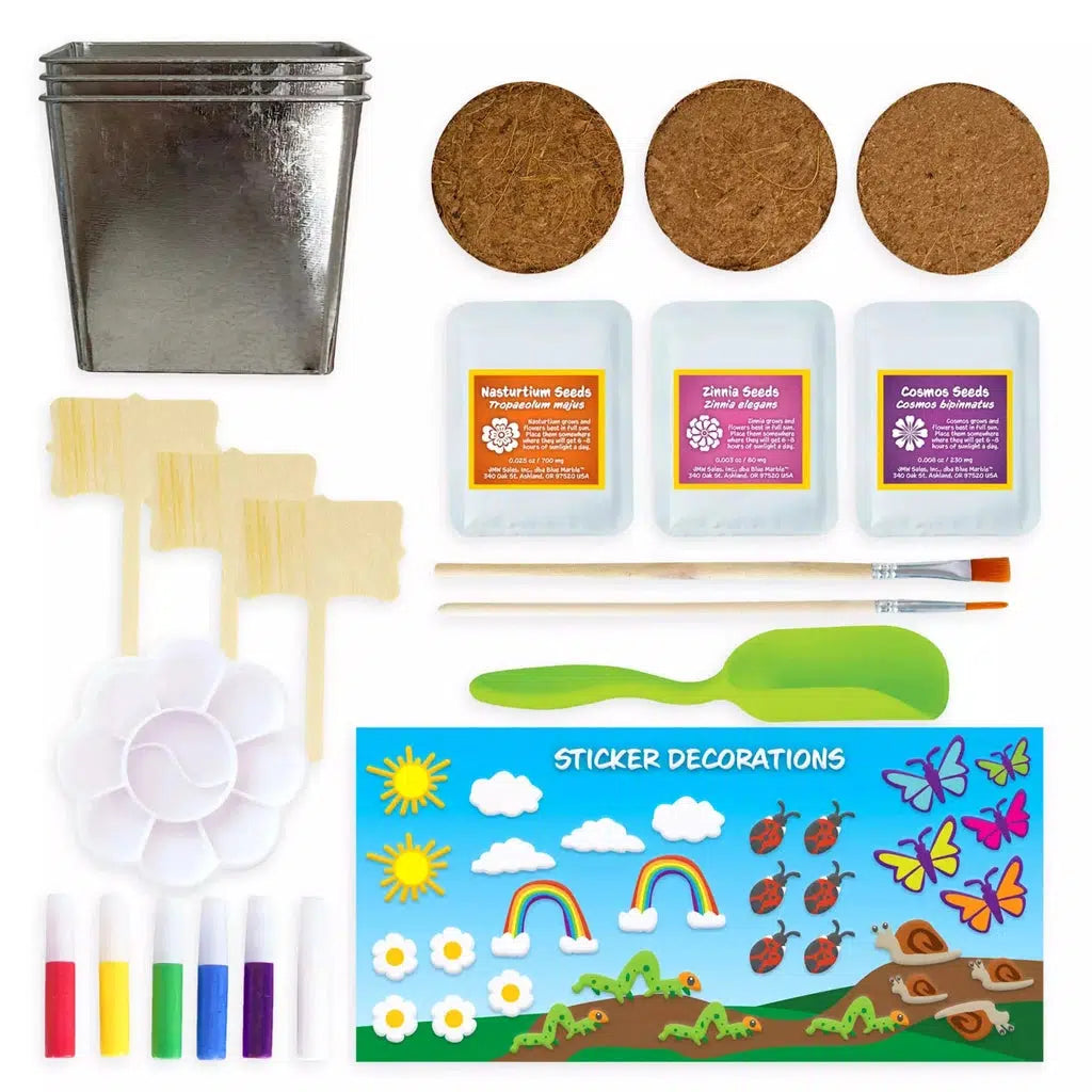 this image shows the three flower pots, three signs for labeling the flowers, and 3 packks of seeds to be planted. there are paint, stickers and brushes to make a lovely garden craft