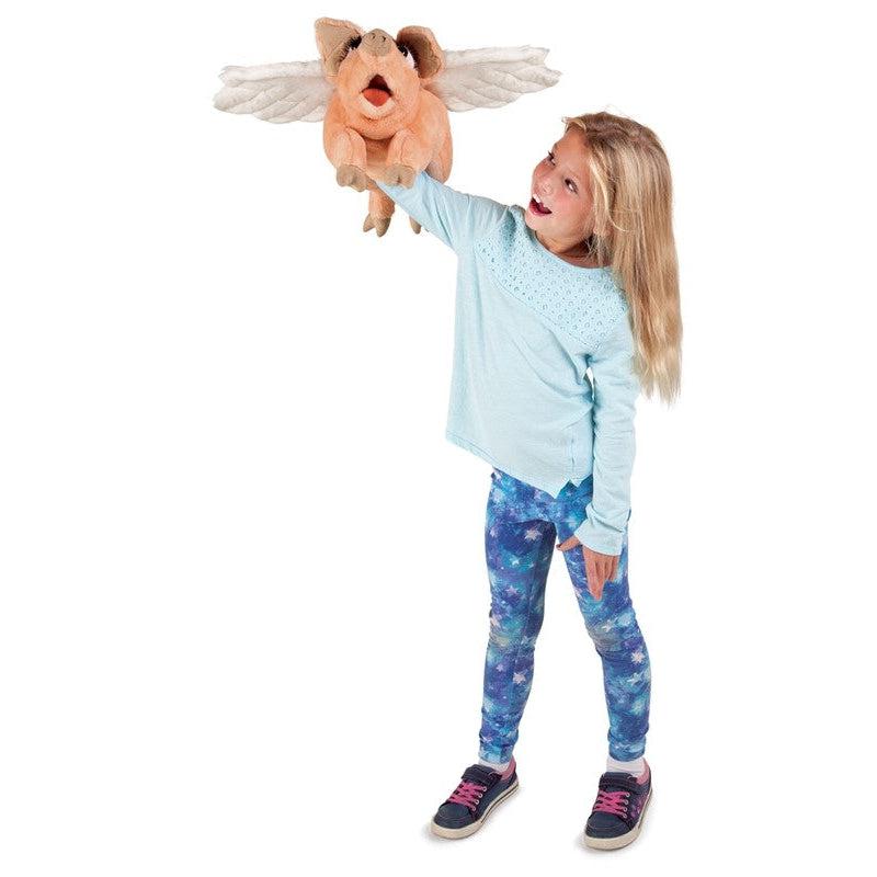 Young girl with puppet on hand making it "fly".