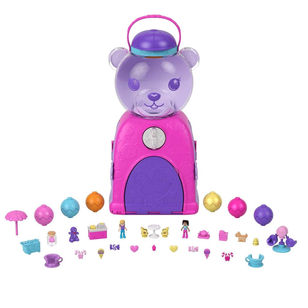Image of all included pieces in the set. It includes a purple and pink bear-shaped gumball machine, six differently colored "gumballs" and multiple different prizes such as Polly pockets, accessories, and treats.