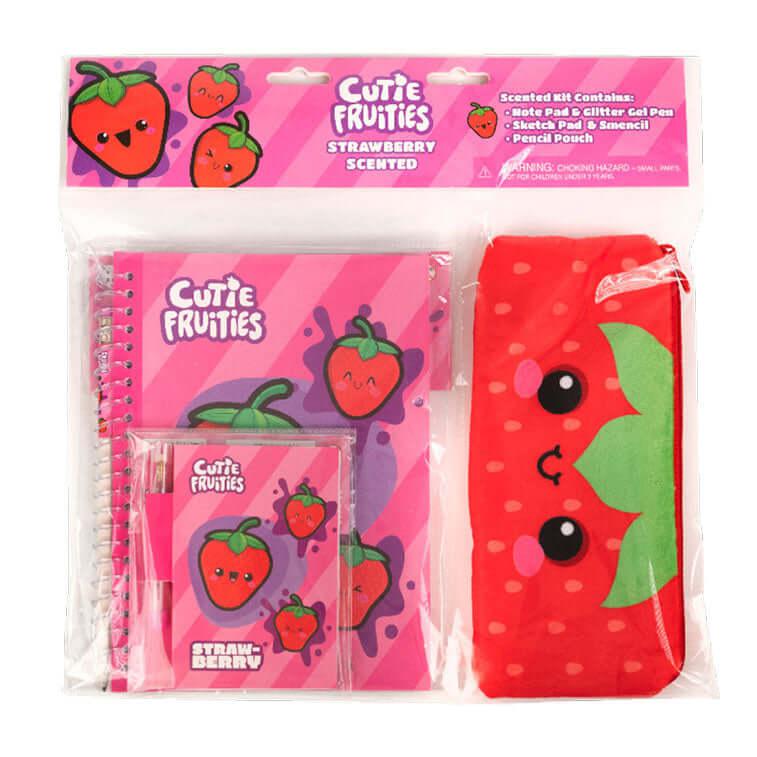 Image of the Strawberry Cutie Fruities Stationary Kit. It includes a strawberry themed notepad, glitter pen, sketch pad, smencil, and pencil pouch. Each strawberry face has pink blushies under their eyes.