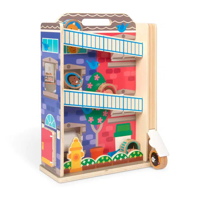 Image of the tumble toy outside of the packaging. It is a wooden structure with slanted slides so the people disks can roll down them to the bottom!  The structure is colored to look like a tall apartment building. It has two sides, a red side and a blue side.