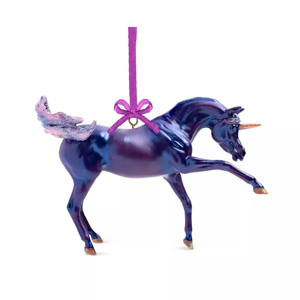 a christmas ornament of a shiny metalic purple unicorn with golden hooves and horn, a pink sparkly tail, and a purple string to hang it from the tree by.
