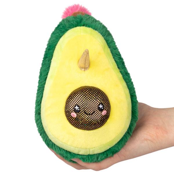 Image of the Unicado Snacker squishable. It is an avocado plush with a sparkly pit, a unicorn horn, and a pink mane.