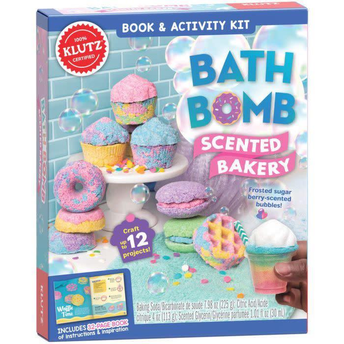 Packaging reads: Book & activity kit, bath bomb scented bakery; frosted sugar berry scented bubbles; includes 32 page book of instructions & inspiration; box displays an array of cupcake and donut and other food shaped bath bombs you can make with the kit.