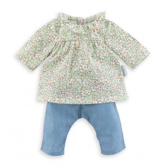 The outfit consists of a green blouse with a print of white flowers with yellow centers, and a pair of light blue jeans
