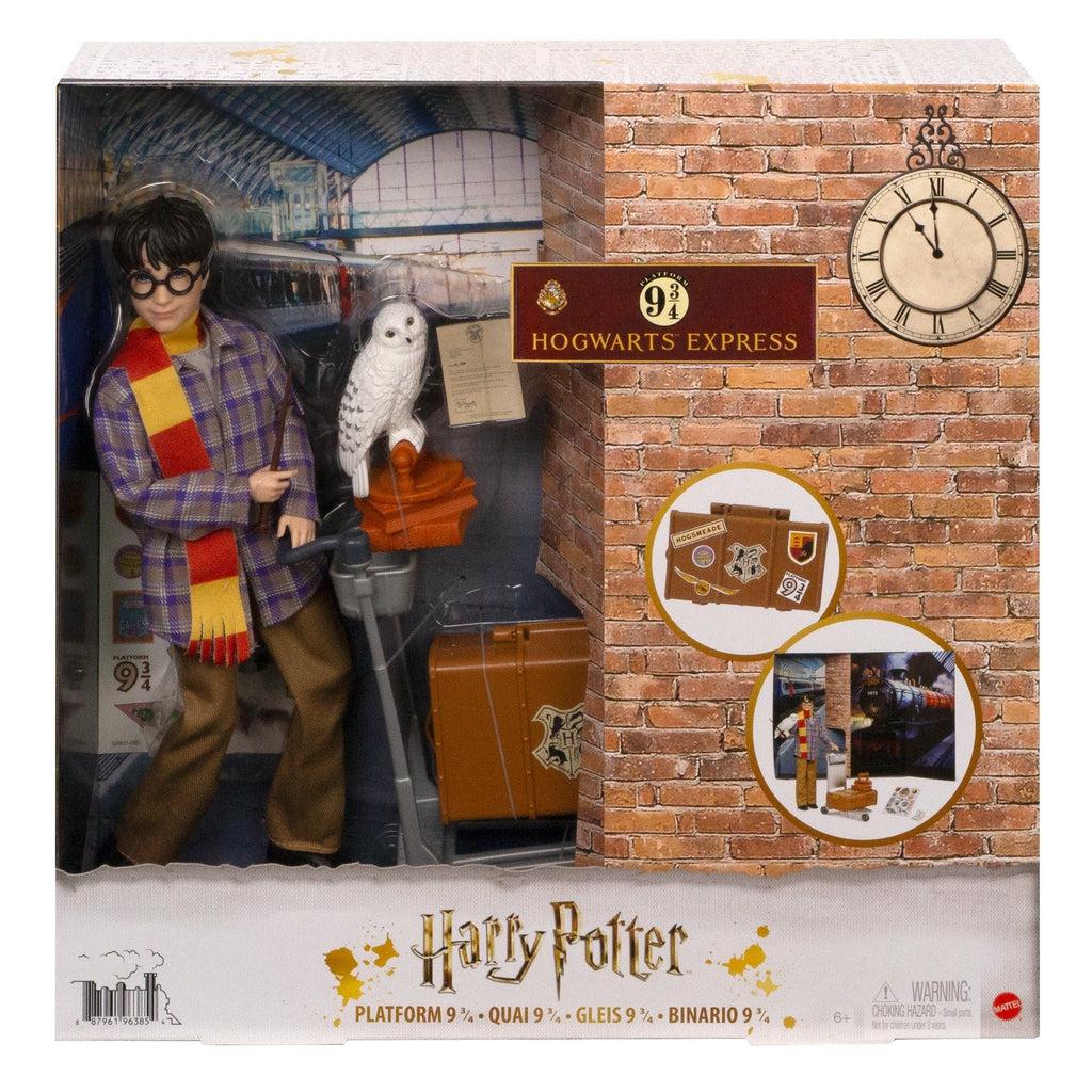 Harry Potter doll in packaging | Front of packaging is half transparent plastic showing the doll with a train station background, other half is cardboard with red brick print and a sign reading "9 3/4 Hogwarts Express" and a clock.