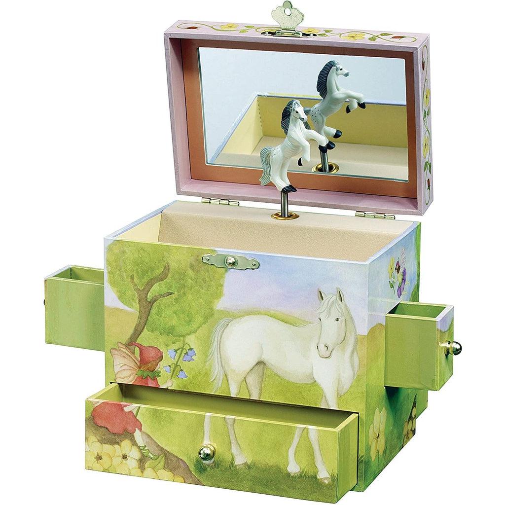 A music box is shown, it has 4 drawers, 1 at the bottom of the front and another on the back in the same place, as well as one in each side right about the middle. The top opens up to reveal a chest style opening with a mirror inside the lid and a white horse with a black mane in front of the mirror. The front depicts the same horse staring at a fairy who is sitting on a hill next to a tree.