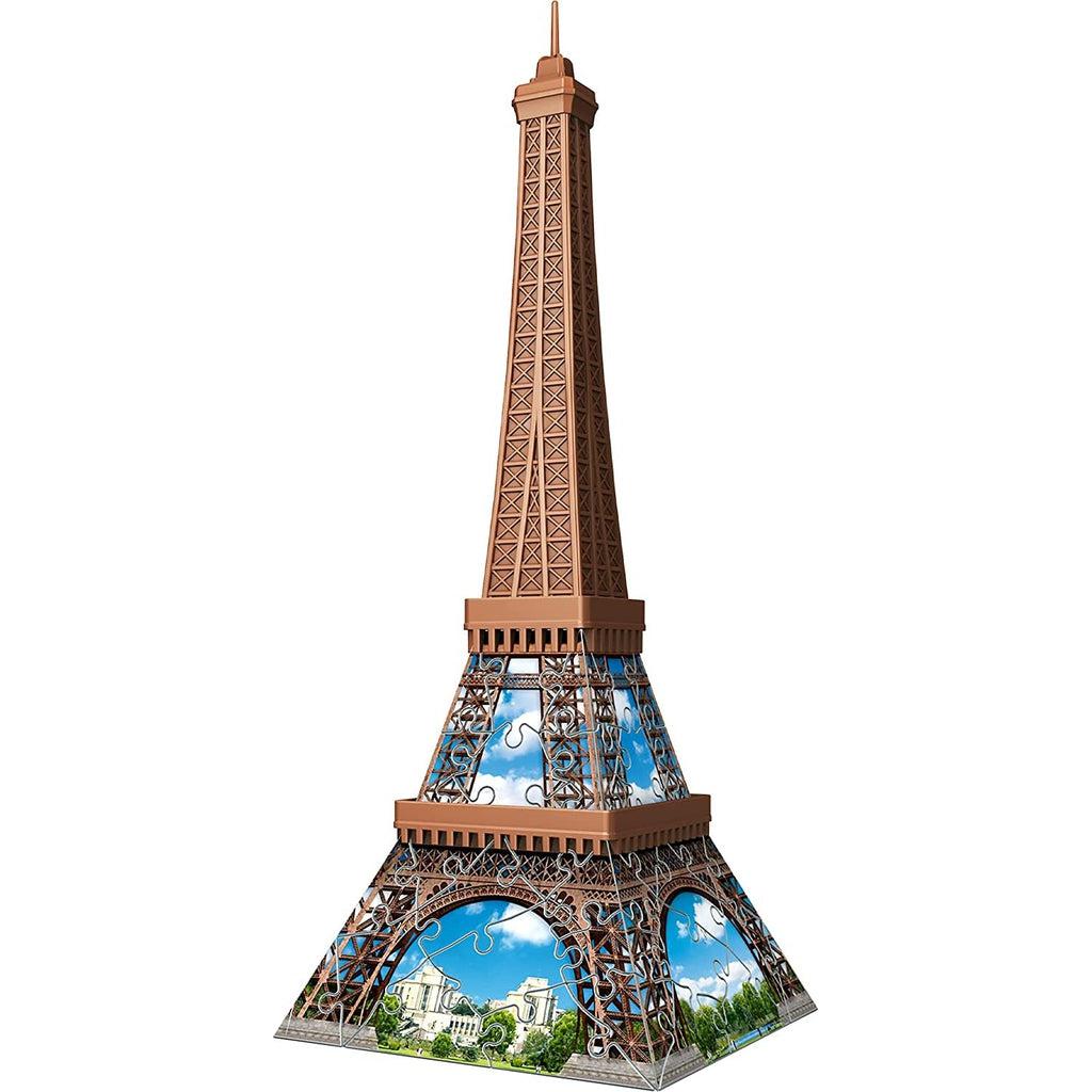 Image of completed puzzle | Puzzle is composed of interlocking jigsaw style pieces | Image can be seen on all 4 sides of the puzzle | Image of Eiffel Tower during the day time, through gaps blue sky with clouds and buildings are visible.