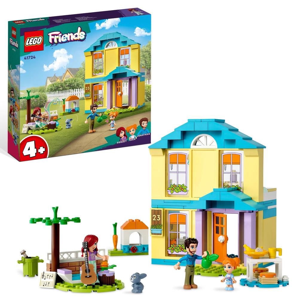 The lego set is shown in front of the box, There is a lego house with an open back, a bench with a tree, a rabbit hutch, and three lego friends characters.