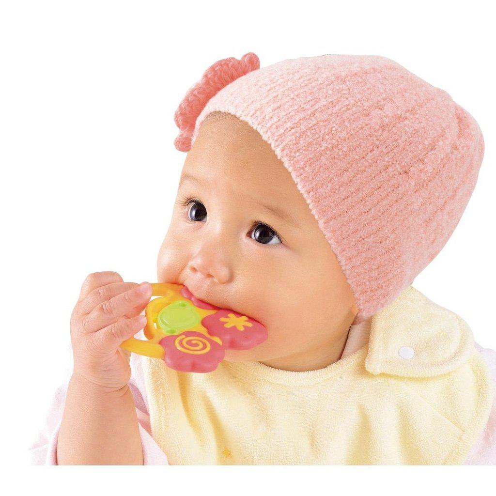 Scene of a baby girl chewing on the toy.