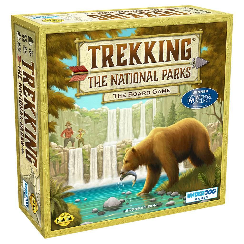 Trekking The National Parks game box | Title of game appears to be against wood planks and framed by sticks with an arrow between the title sections. | Image on the box shows a scenic illustration of waterfalls pouring into a river where a bear is catching a fish in it's mouth. Two people look over the scene, and trees frame the picture as a whole.
