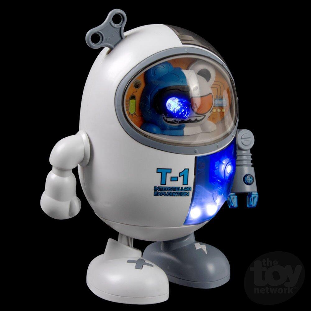 A white, egg-shaped walking toy robot labeled "T-1" with a wind-up key, transparent dome helmet, glowing blue lights, and mechanical arms and feet—this dancing robot brings playful charm to any collection.