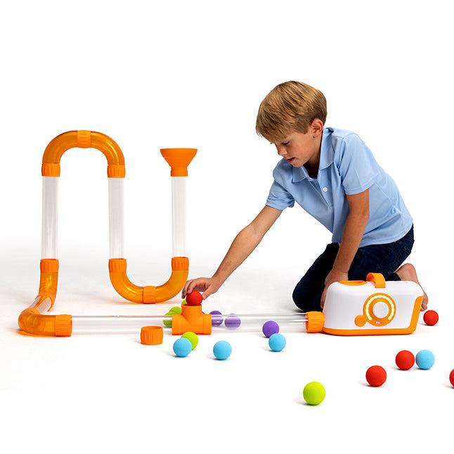 a small child is building a track that will launch foam balls straight into the air. 