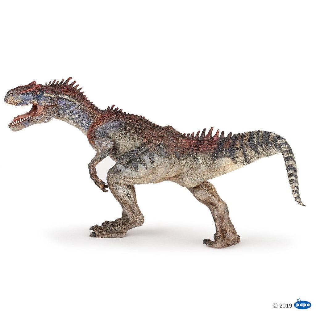 Image of the Allosaurus figurine. It is a tan, black, and red dinosaur that stands on two legs. It has lots of small spikes on the ridge of its back.