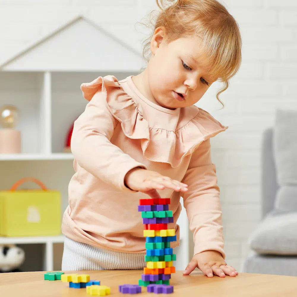 this image shows a little girl stacking with the blicks. the blocks are as big as her hand, and safe to play with. 