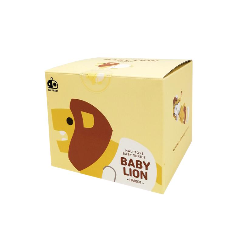 Image of the packaging for the Baby Lion and Crib figurine toy. The box is a light yellow cube with a 2D picture of the figurine on the side.
