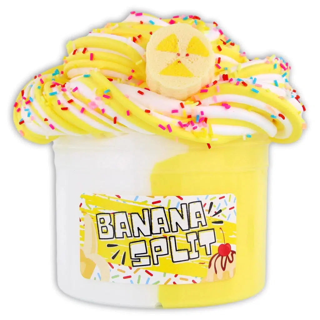 Image of the open Banana Split slime. It is a dual colored opaque slime with one side being white and the other being yellow. It is topeed with rainbow sprinkles and comes with a banana charm.