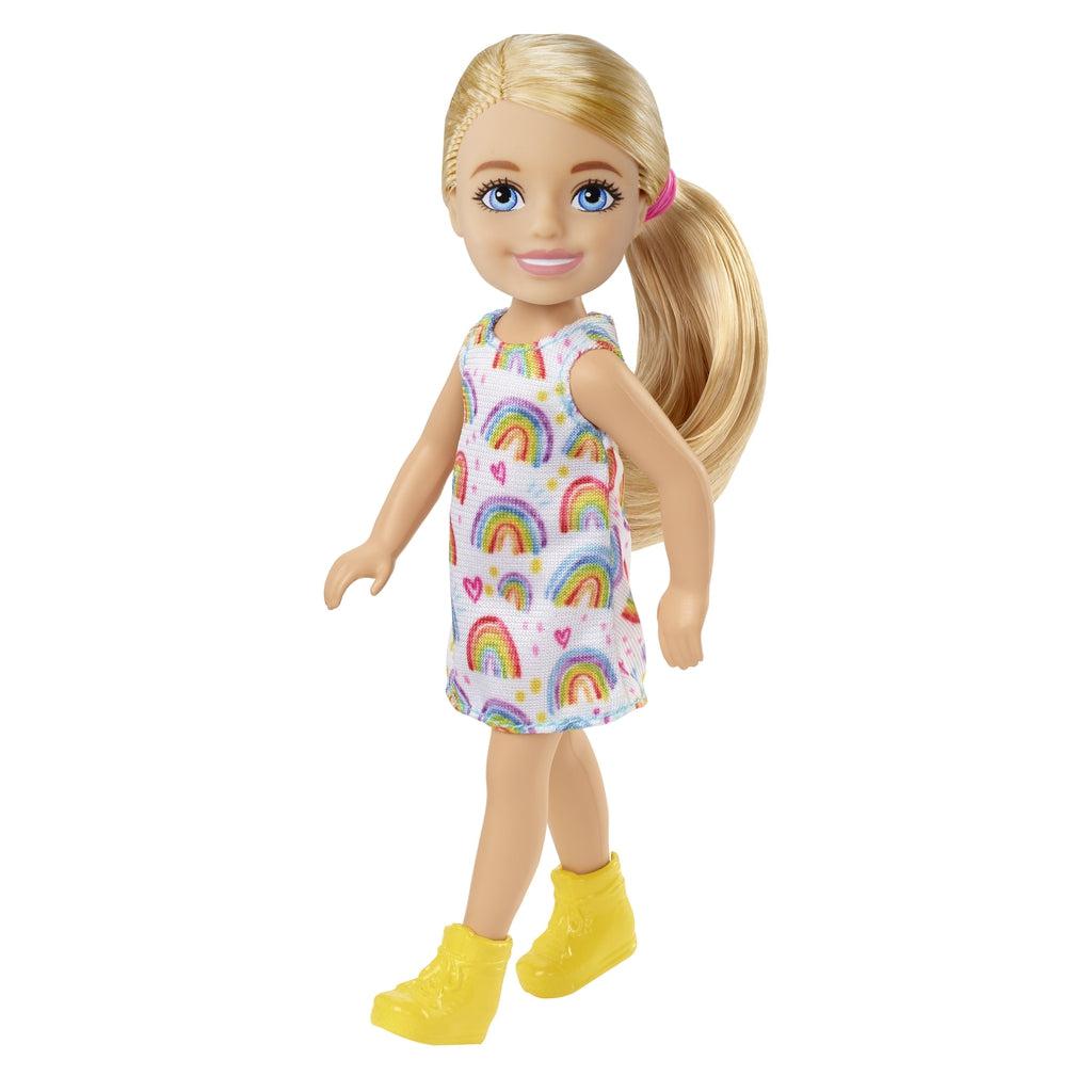 Image of Chelsea out of the packaging. She is wearing a dress with rainbows on it and yellow shoes.