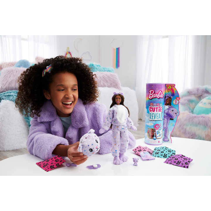 Scene of a little girl excitedly smiling as she reveals her Barbie's outfit.