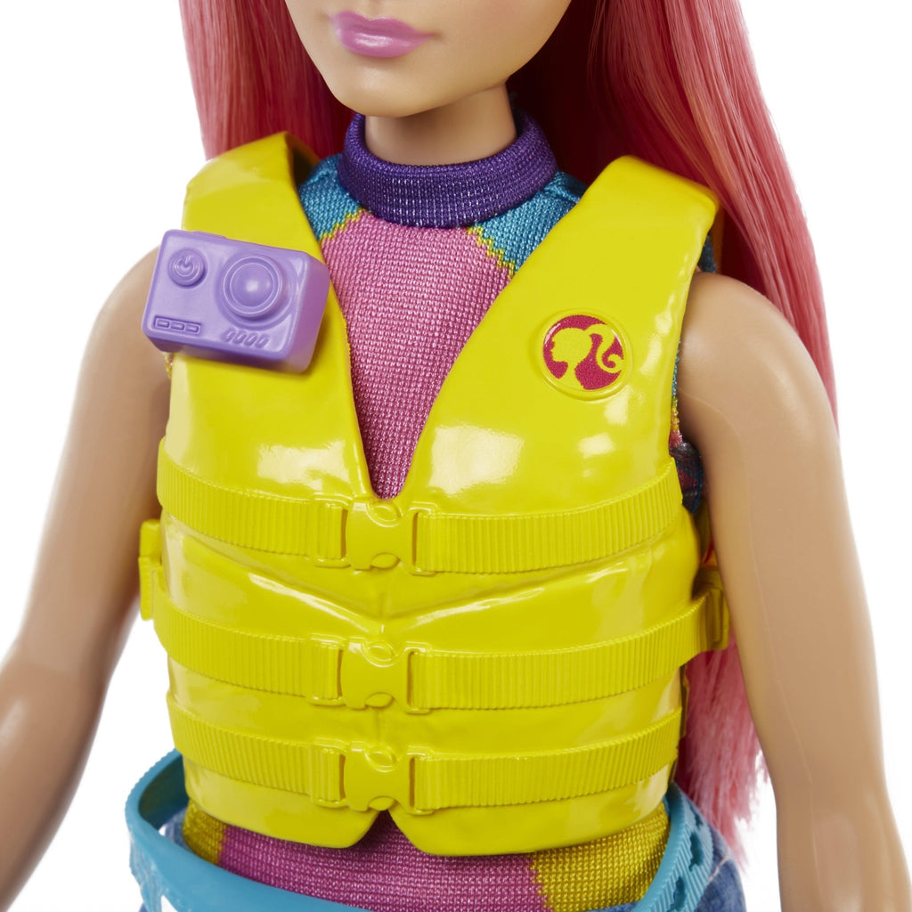 Up close shot of Daisy's life jacket. It is yellow with a pink Barbie logo on one side. On the other side is a place where you can attach the included camera.