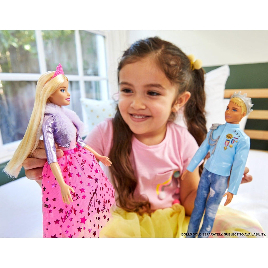 Scene of a little girl smiling while introducing Princess Barbie to Prince Ken.