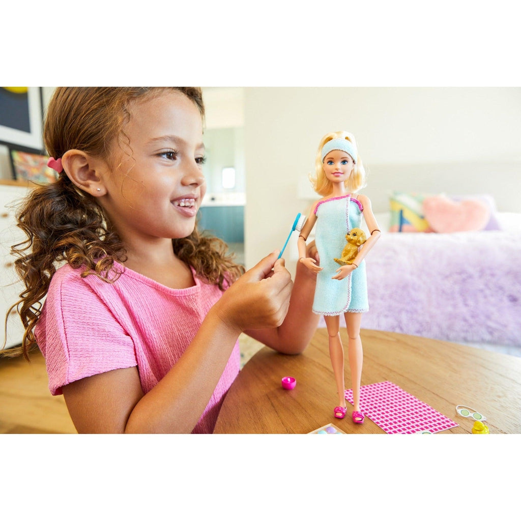 Scene of a little girl smiling while taking care of Barbie.