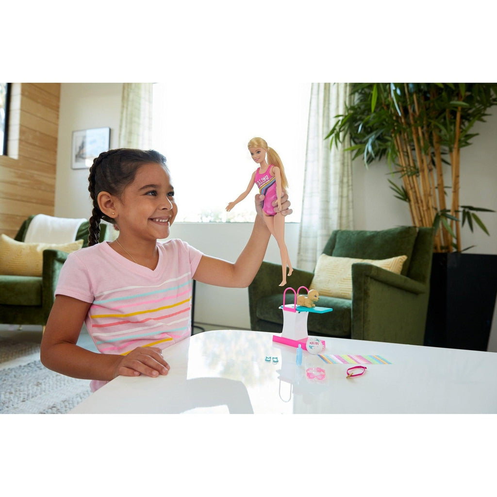 Scene of a girl smiling while playing with Barbie.