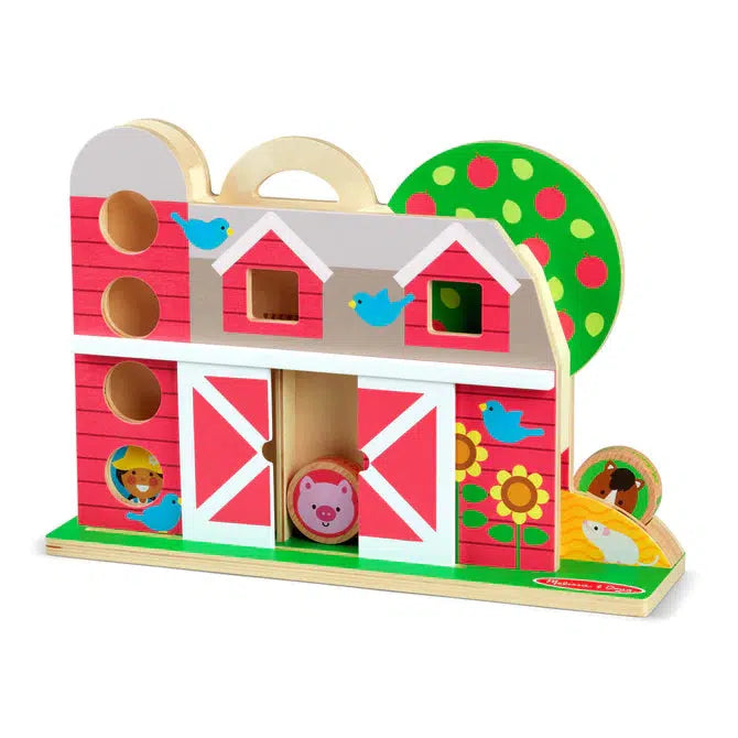Image of the toy outside of the packaging.  It is a wooden structure of a farm barn. The front of the barn has sliding barn doors that reveal places that the disks can tumble. There are also some other areas for storage and tumbling for the character disks.