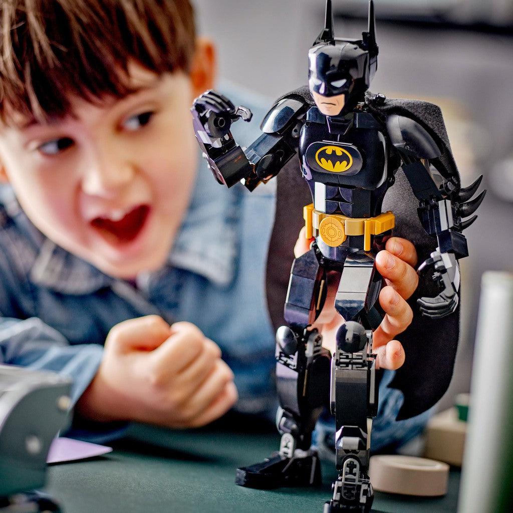 image shows a kid holding the LEGO Batman construction Figure