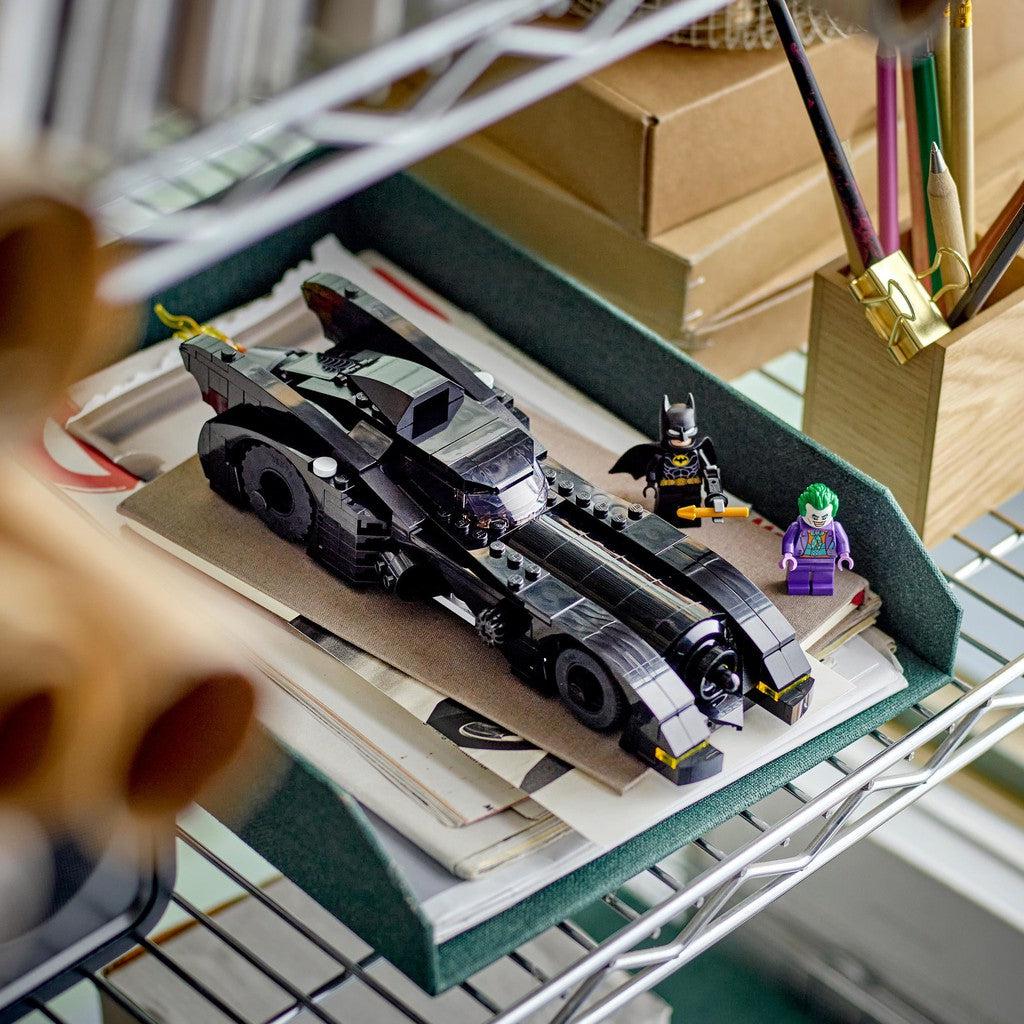 image shows teh completed batmobile sitting on a shelf with batman and joker