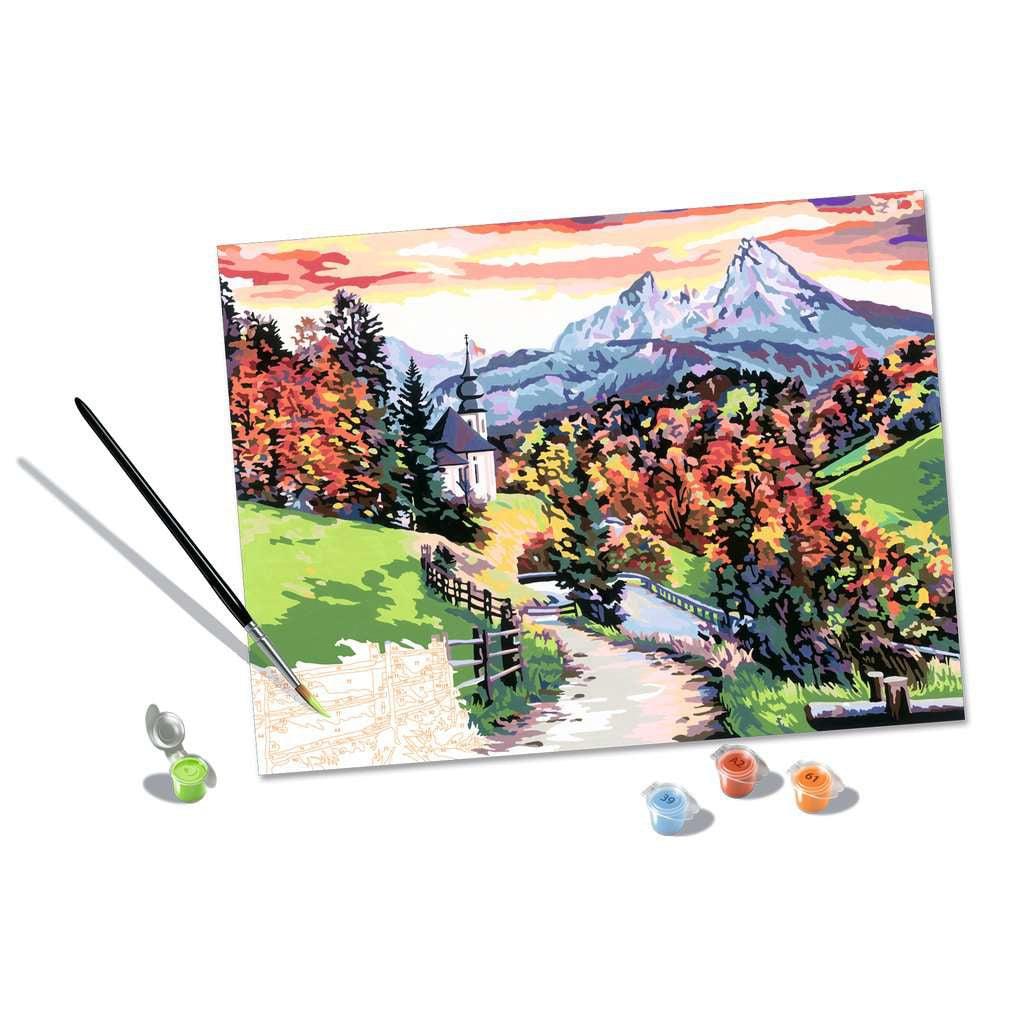 this picture shows a paintbrush dissped in green adding grass by the fance, while showing what the numbers in the paint by numbers kit liik like to create this artwork. 