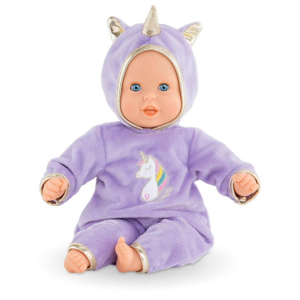 Image of the doll outside of the box. It is dressed in a purple unicorn themed outfit complete with a picture of a unicorn on the belly and a horn on the hood.