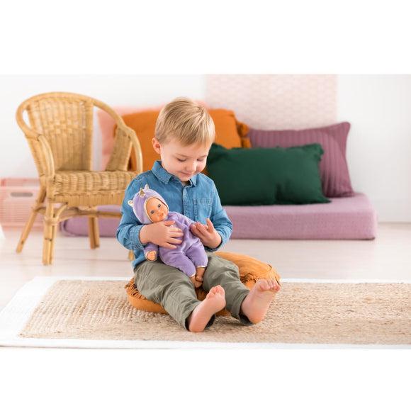 Scene of a little boy holding and cradling the baby doll while smiling.