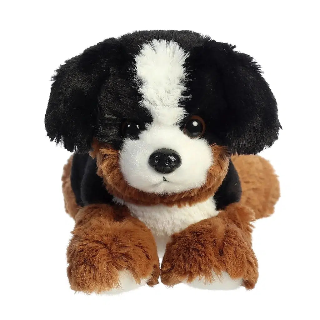 Image of the Bernie Mountain Dog plush. He is brown, black, and white with brown eyes. He is laying on his belly.