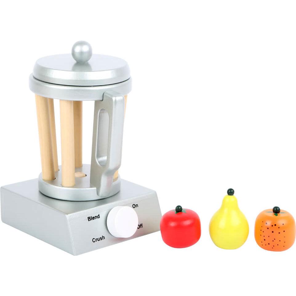 Shows all the included pieces outside of the packaging. The set includes a blender with detachable lid and knob, an apple, a yellow pear, and an orange.