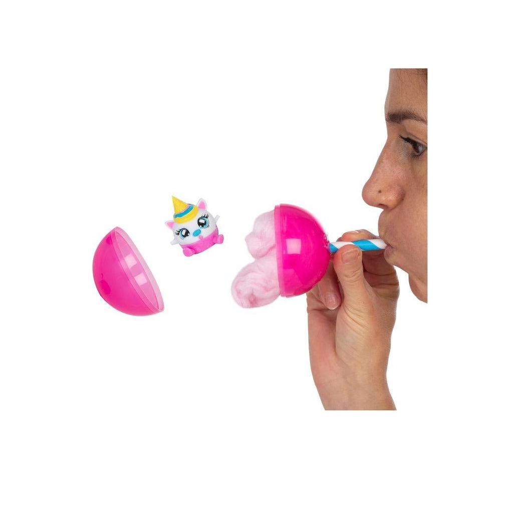 Shows a girl blowing into the capsule to pop the character out.