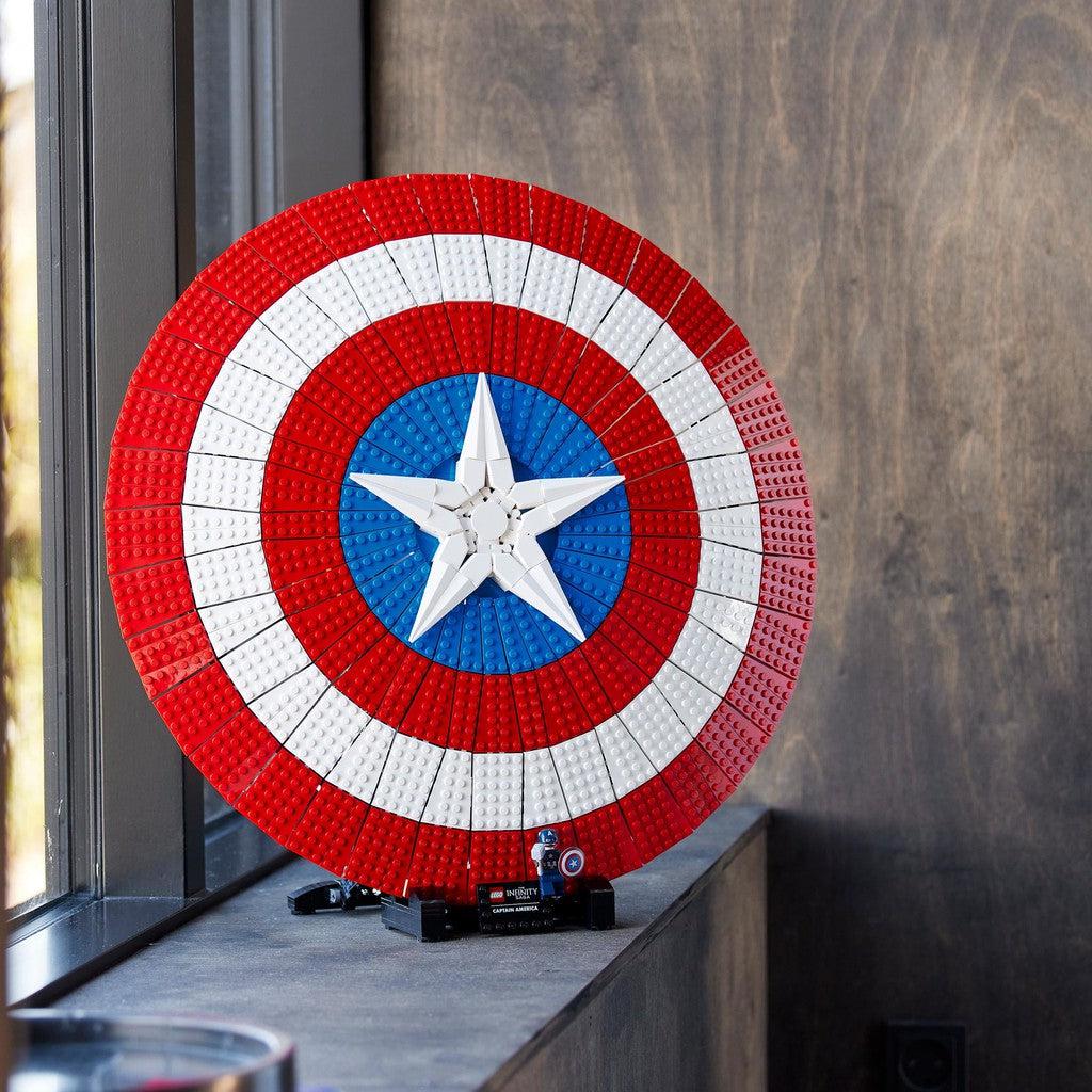 image shows the massive shield on a stand with a small Captain America next to it by the window