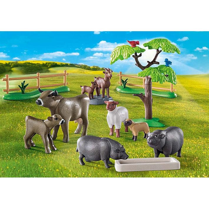 this image shows the animals in more detail, the pigs are eating from a troth, a cow and baby cow are grazing with a sheep and baby sheep, and a goat and baby goat are in the back. there is a fence and tress as well to add color to the play area.  
