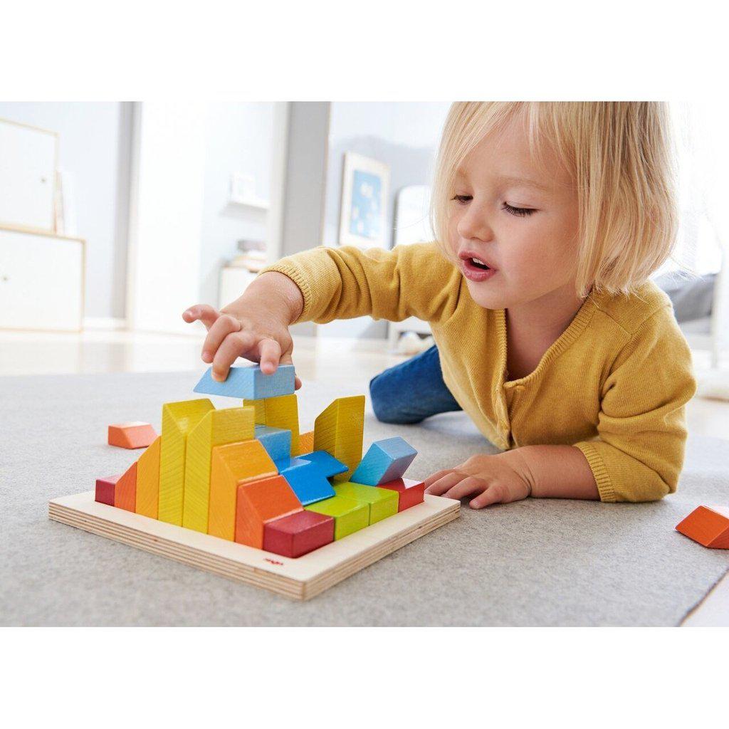 Scene of a little girl building a structure with the toy blocks.