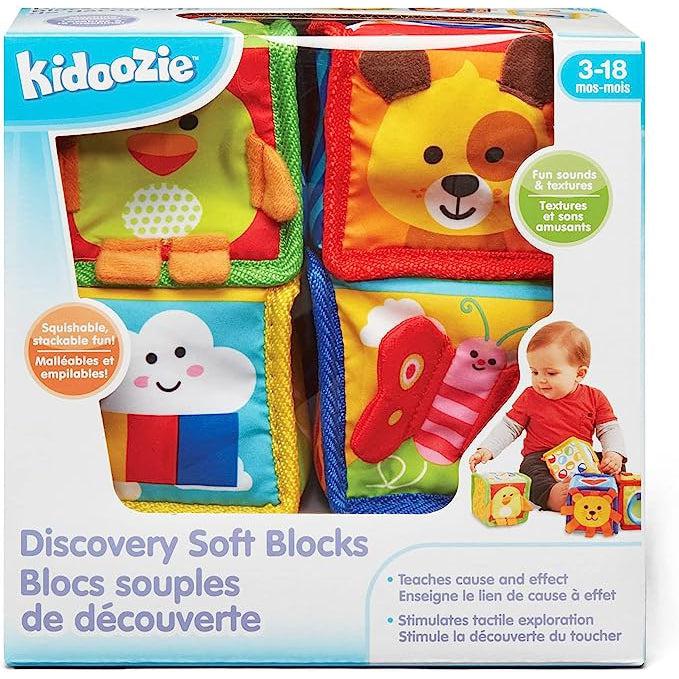 Image of the packaging for the Discovery Soft Blocks baby toy. Part of the front is cut away so you can see and touch the toy inside.