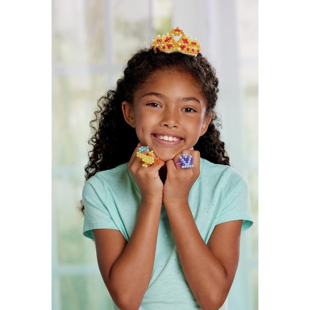 a younge girl who made the aquabead tiara and Disney princess accessories to use as rings. 