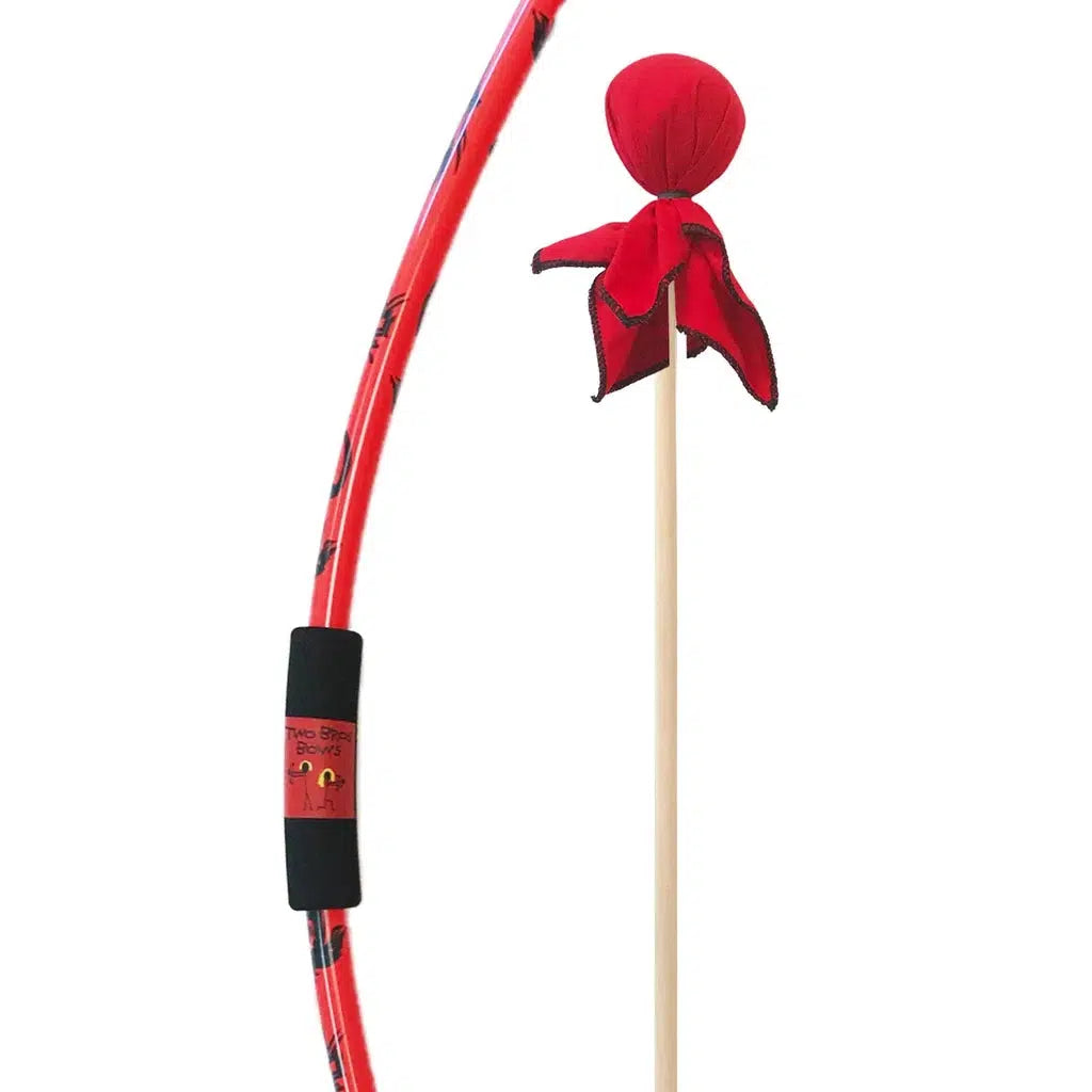 close up of the red bow with black dragons printed along it and a foam handle next to an arrow with a large soft rounded red tip